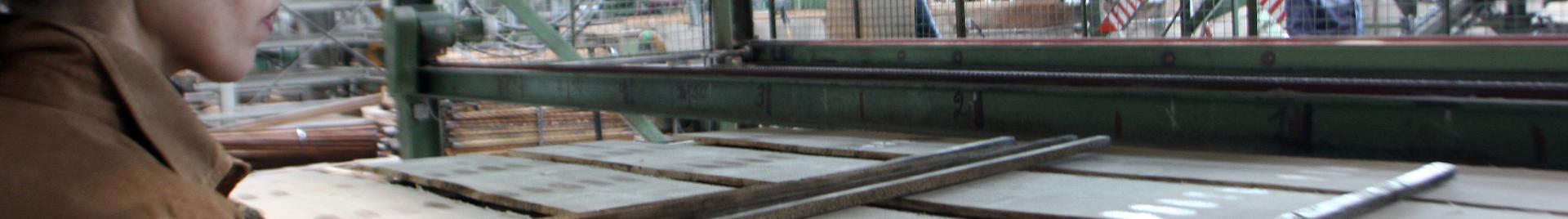 Factory worker piling timber products